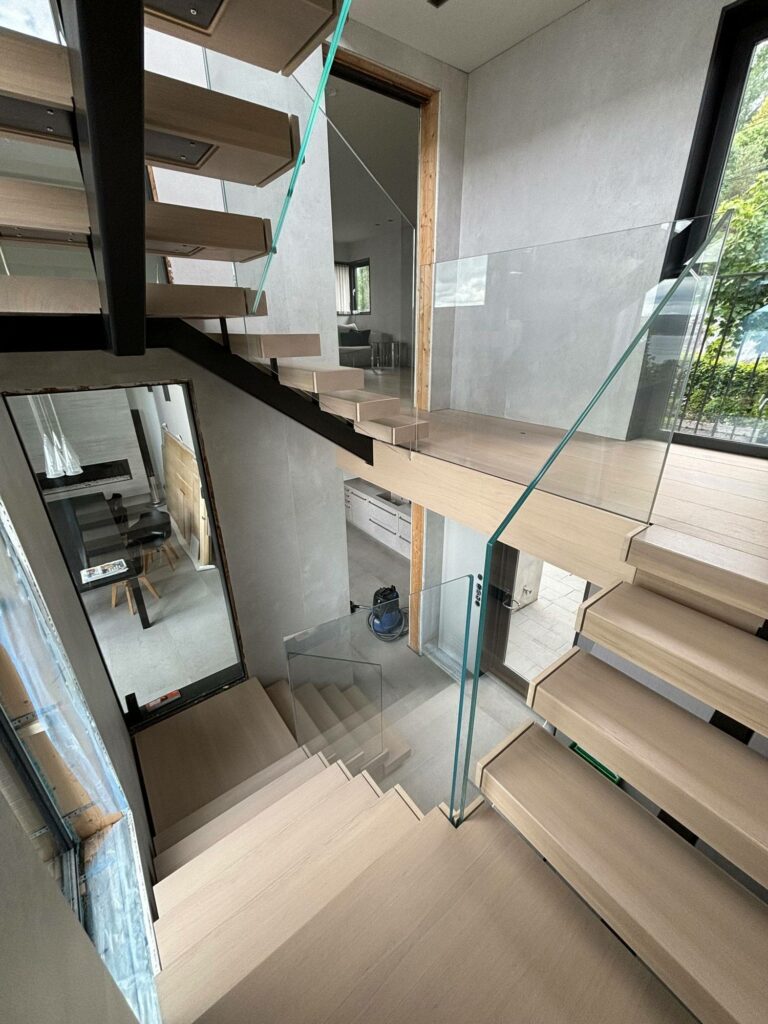 Eiketrapp med midtvange i stål og rekkverk i glass