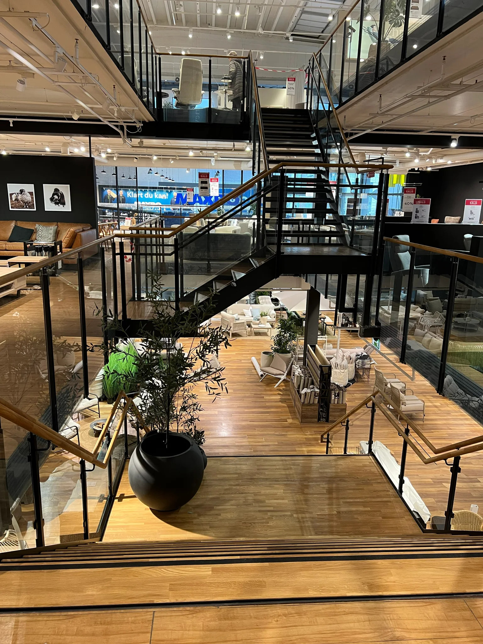 Ståltrapp med glassrekkverk mellom butikketasjene hos Skeidar Alnabru